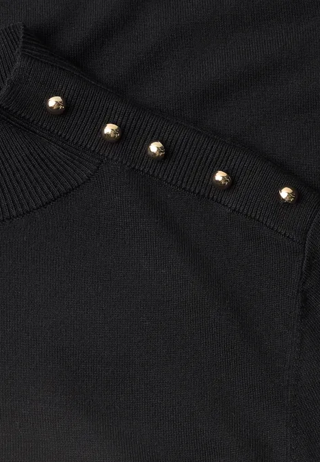Pullover mit Turtle Neck und Knopfdetails Black Nahaufnahme von schwarzem Stoff mit goldfarbenen Nieten an der Kante.