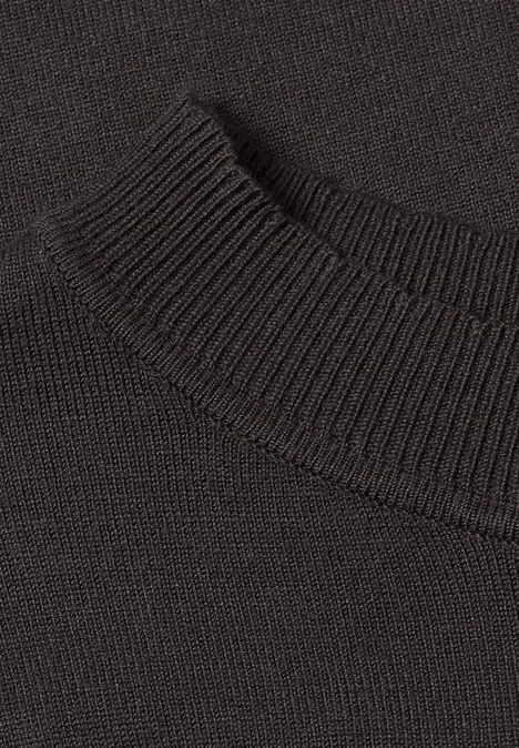 Nahaufnahme eines schwarzen, fein gestrickten Pullovers mit geripptem Kragen.