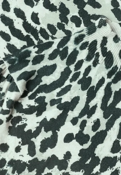 Close-up van een textiel met onregelmatige zwart-witte vlekken in dierenprintstijl