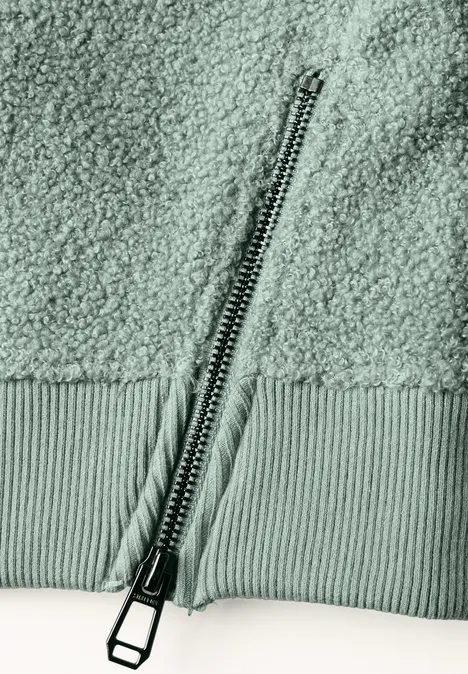 Teddy-Sweatshirt mit Zipperdetails eucalyptus green Nahaufnahme eines Reißverschlusses an einem weichen, strukturierten Teddy-Fleece-Stoff.
