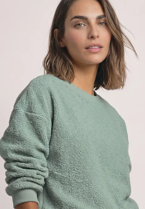 Teddy-Sweatshirt mit Zipperdetails eucalyptus green Frau mit braunen Haaren trägt locker sitzenden, hellgrünen Fleecepullover vor hellem Hintergrund.