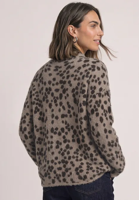 Frau mit braunem Pullover im schwarzen Leopardenmuster, seitlich von hinten