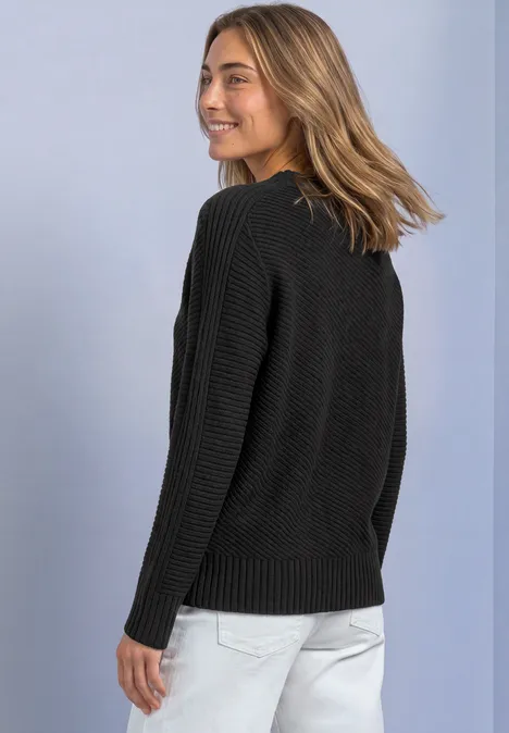 Langarm Pullover mit Turtle Neck und Struktur armor grey mel. Frau in schwarzem Pullover und heller Hose blickt lächelnd über die Schulter.