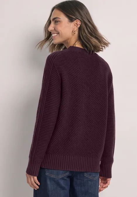 Langarm Pullover mit Turtle Neck und Struktur berry plum Eine Frau mit schulterlangen Haaren trägt einen weinroten Strickpullover und lächelt seitlich.