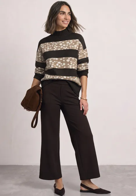 Jacquard Pullover mit Turtle Neck black coffee mel. Frau trägt gestreiften Pullover und braune, weite Hose, hält Tasche in der Hand.