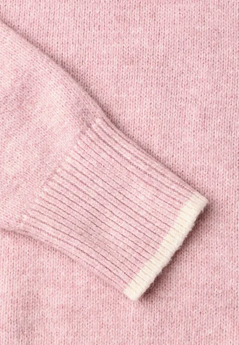 Pull uni à col rond quiet rose mel. Nahaufnahme eines rosa gestrickten Pullovers mit Rippbündchen.