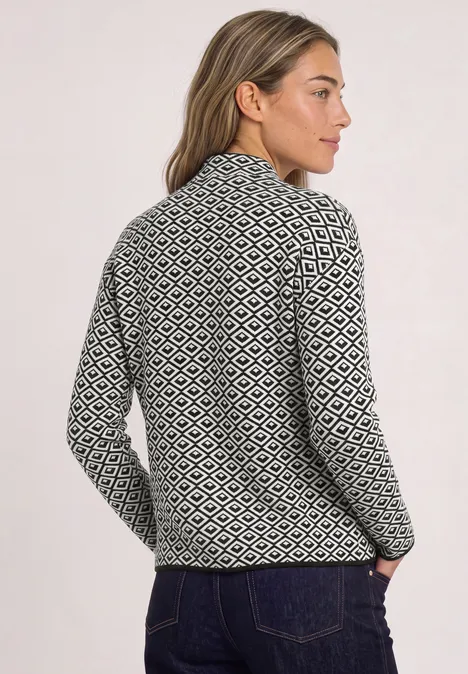 Frau in schwarz-weiß gemustertem Strickpullover mit Stehkragen, Rückansicht leicht seitlich.