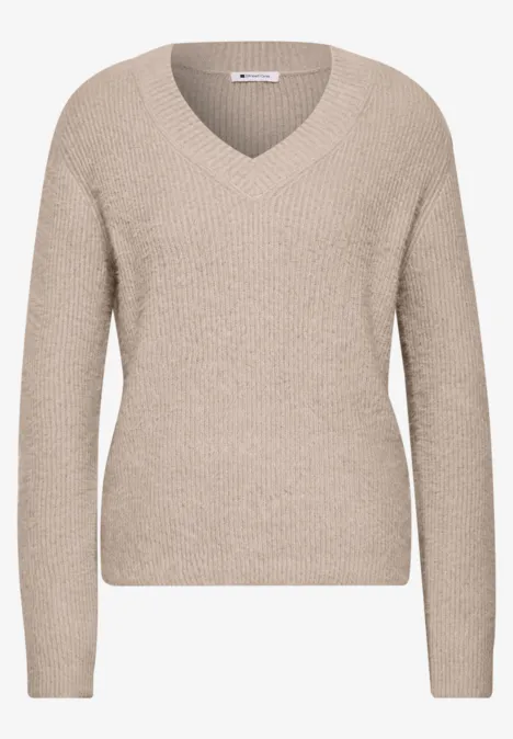 Beiger V-Ausschnitt-Pullover mit langen Ärmeln aus weichem Strick.