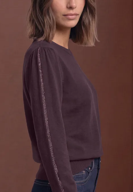 Pullover mit Rundhals und Glitzertape berry plum Seitliches Porträt einer Frau im weinroten Langarm-Pullover vor braunem Hintergrund.