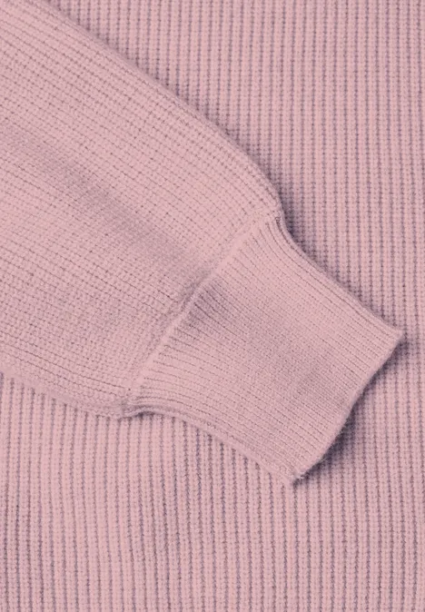Nahaufnahme eines rosa gerippten Pullovers mit Bündchen am Ärmel.