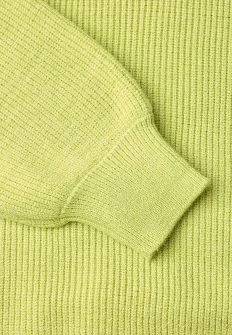 Nahaufnahme eines limettengrünen Strickpullovers mit Rippstrick und Bündchen.