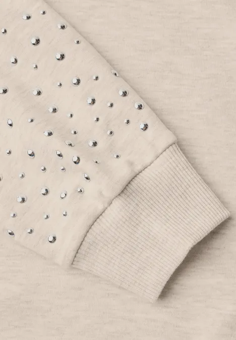 Beiger Sweatshirtärmel mit Rippenbündchen, verziert mit glänzenden Strasssteinen.