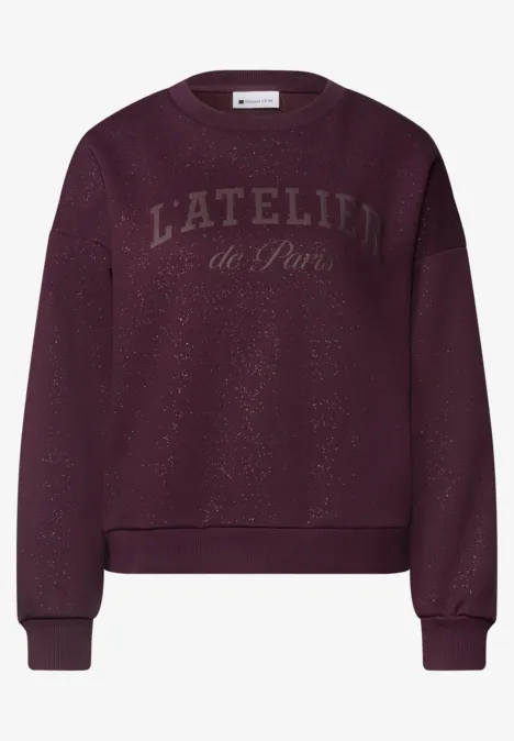 Loose Fit Sweatshirt mit Glitzer berry plum Dunkelvioletter Pullover mit 'L'ATELIER de Paris'-Schriftzug vorne.
