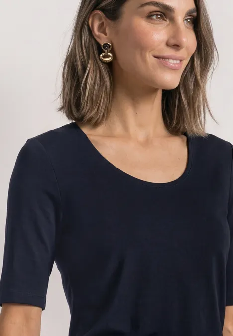 Basic T-Shirt mit blickdichter Front deep blue Frau mit schulterlangen Haaren, trägt schlichtes schwarzes Shirt mit Rundhals, halblangen Ärmeln und goldenen Ohrringen.