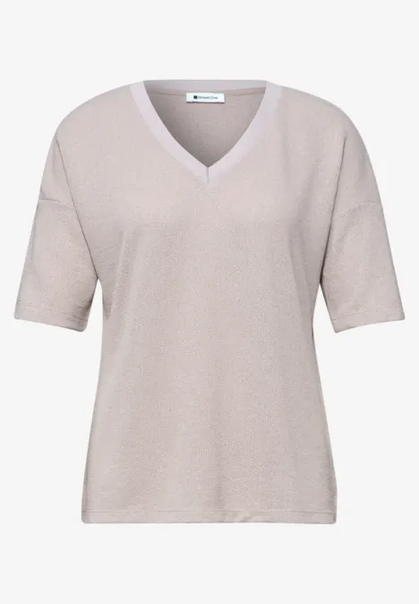 Beige top met V-hals en halflange mouwen.