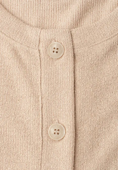 Beige gebreid vest met ronde hals en twee knopen.
