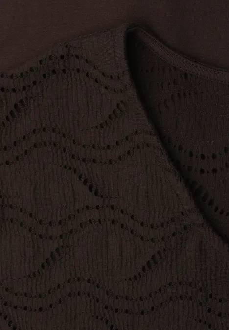 Close-up van een donkerbruin gebreide stof met een golvend open patroon.