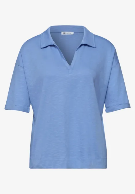 Lichtblauw poloshirt met korte mouwen en V-hals.