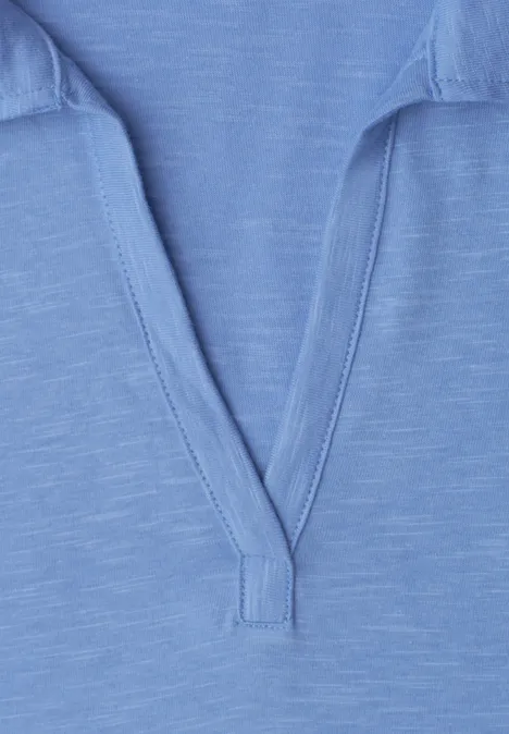 Close-up van een lichtblauw t-shirt met V-hals.