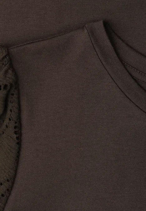 Close-up van een bruin kledingstuk met ronde hals en kanten inzetstuk aan de mouw.