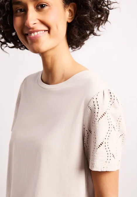 Beiges T-Shirt mit Rundhalsausschnitt und perforierten Ärmeln, lockere Passform.