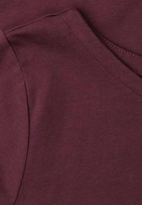 Basic T-Shirt mit U-Boot-Ausschnitt rustic rouge Nahaufnahme einer aufgesetzten Tasche an einem weinroten Kapuzenpullover.
