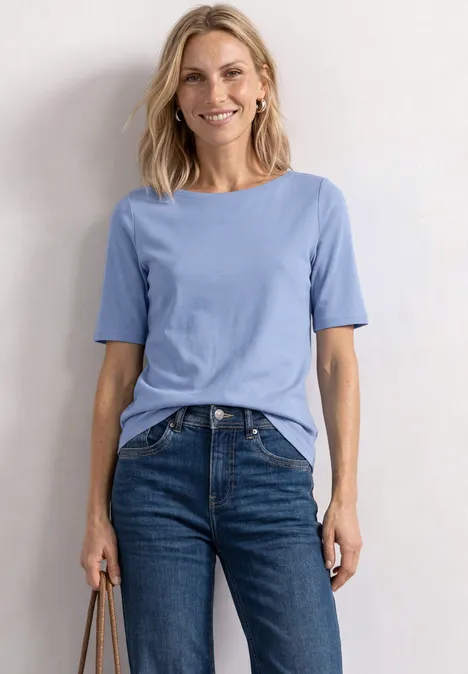 Basic T-Shirt mit U-Boot-Ausschnitt northern blue Eine Frau trägt ein hellblaues T-Shirt, blaue Jeans und hält eine Tasche.