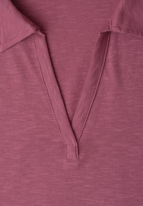 Close-up van een fuchsia roze T-shirt met V-hals en vlakke kraag.