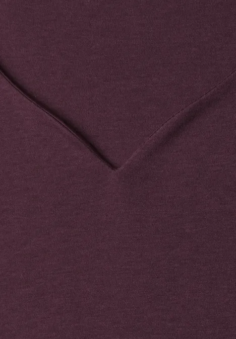 Nahaufnahme eines weinroten V-Ausschnitt-Shirts aus weichem Stoff