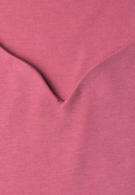 Nahaufnahme eines rosa Stoffes mit V-förmiger Naht.
