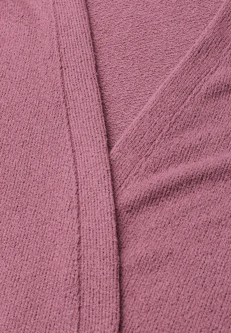 Gros plan sur un tissu texturé rose avec couture
