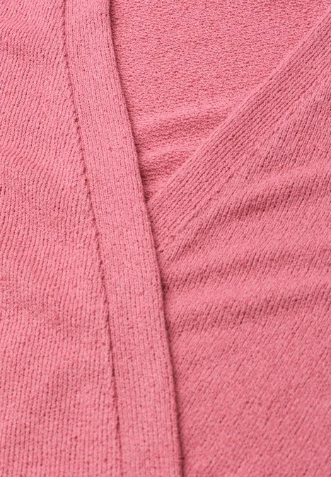 Gros plan sur un tissu rose texturé avec couture et plis