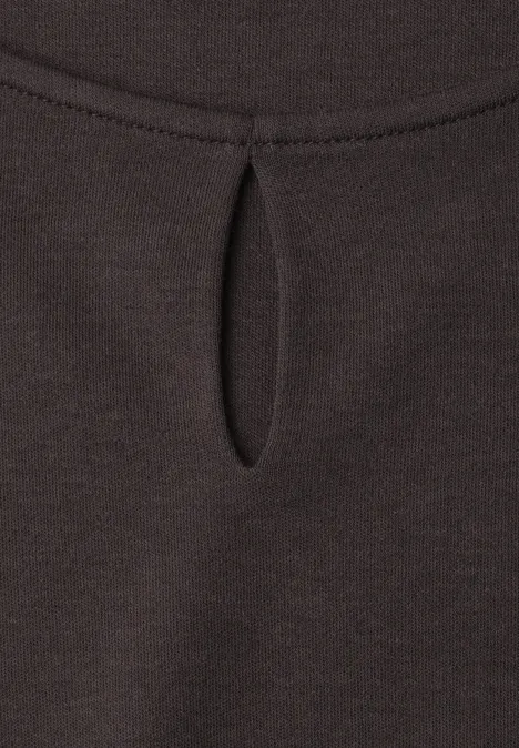 Dunkelbraunes Shirt mit kleinem, tropfenförmigem Schlitz am Ausschnitt.