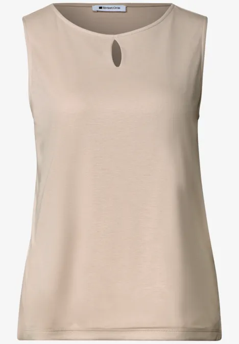 Mouwloze beige top met kleine druppelvormige uitsparing bij de ronde hals.