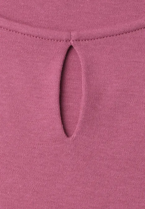 Roze top met een kleine druppelvormige uitsnijding bij de halslijn.