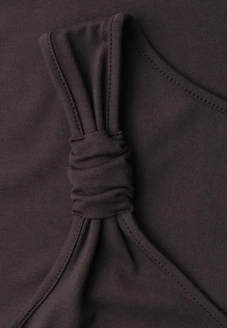 Schwarzes Top mit schmalem Träger und dekorativem Knoten im elastischen Stoff.