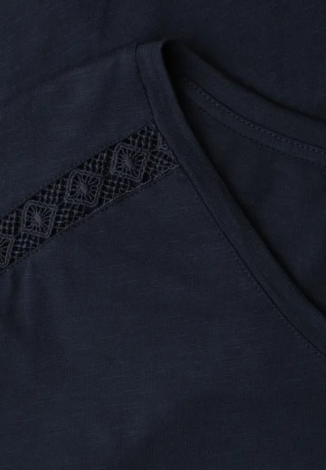 Dunkelblaues T-Shirt mit Brusttasche und filigraner Spitzeneinfassung am Ausschnitt.