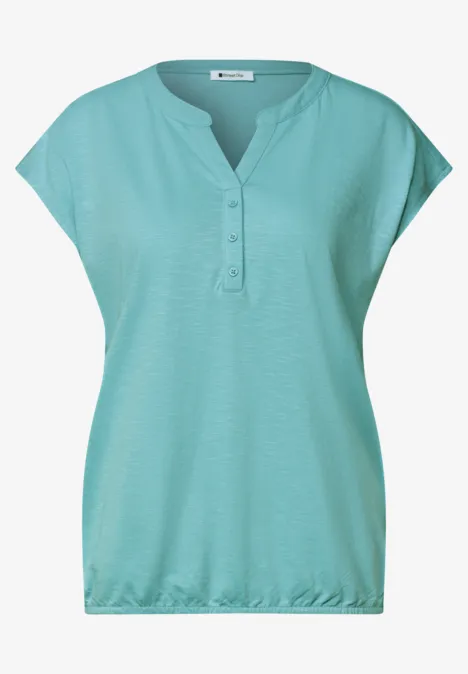 T-shirt femme turquoise, coupe ample, manches courtes tombantes, col en V et patte de boutonnage 3 boutons.