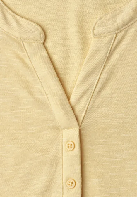Dropped Shoulder Shirt mit Split Neck soft yellow Nahaufnahme eines hellgelben Oberteils mit V-Ausschnitt und zwei Knöpfen