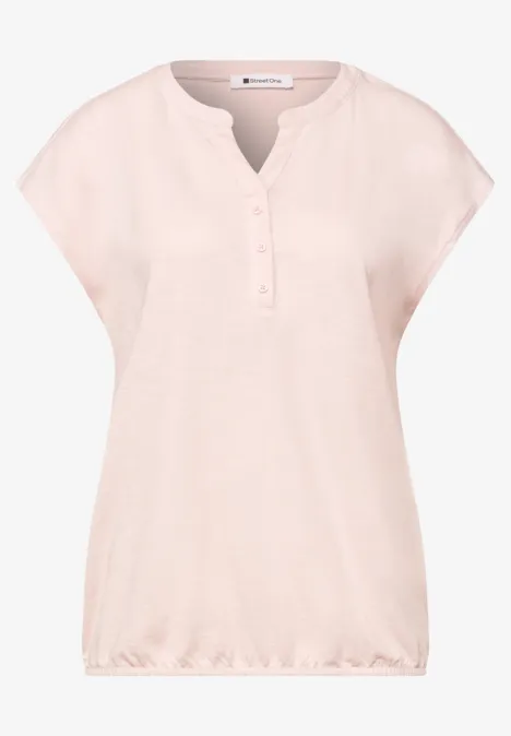 Losvallend lichtroze damesshirt met korte mouwen, knoopsluiting bij de hals en elastische zoom.