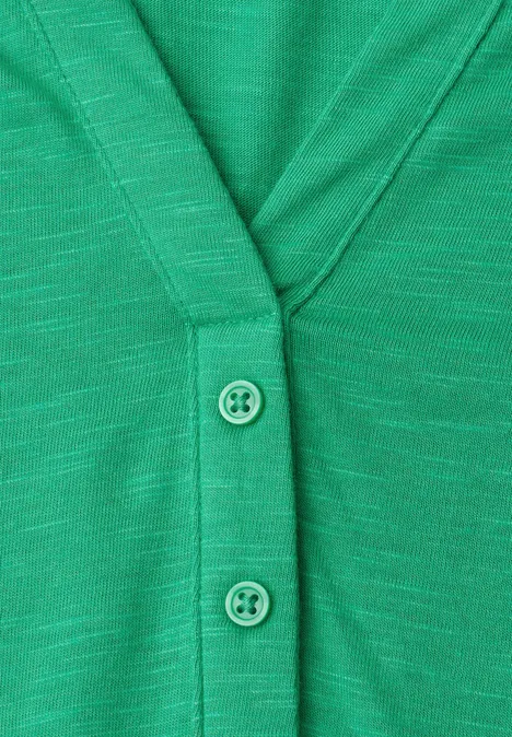 Groene gebreide cardigan met V-hals en twee knopen.