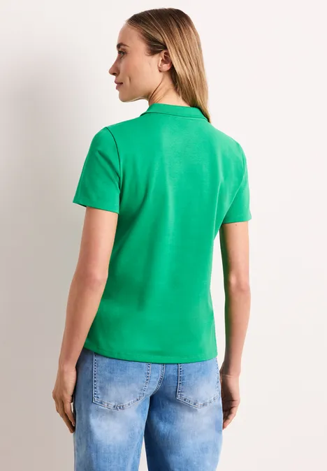 Persoon van achteren met groene polo en blauwe jeans