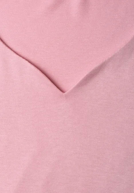 Ein rosa Stoff mit einer V-förmigen Falte.