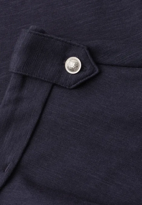 Shirt met gespleten hals en knoopdetails shadowed navy Detail van een donkerblauwe stoffen broek met een zilverkleurige drukknop op de klep
