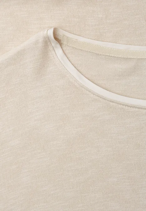 Close-up van een lichtbeige katoenen T-shirt met ronde hals.