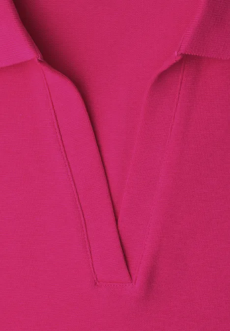 Close-up van een felroze poloshirt met V-hals