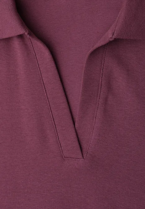 Close-up van een bordeauxrood poloshirt met een open V-hals.