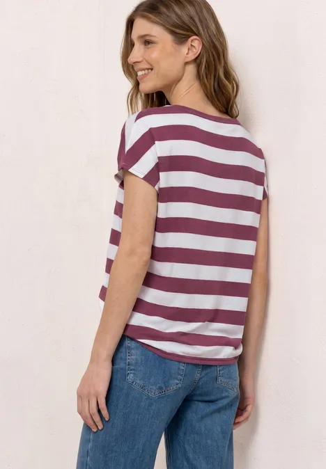 Shirt met korte mouwen, ronde hals en print dark clouded blush Vrouw van achter gefotografeerd in wit-bordeaux gestreept T-shirt en blauwe jeans.