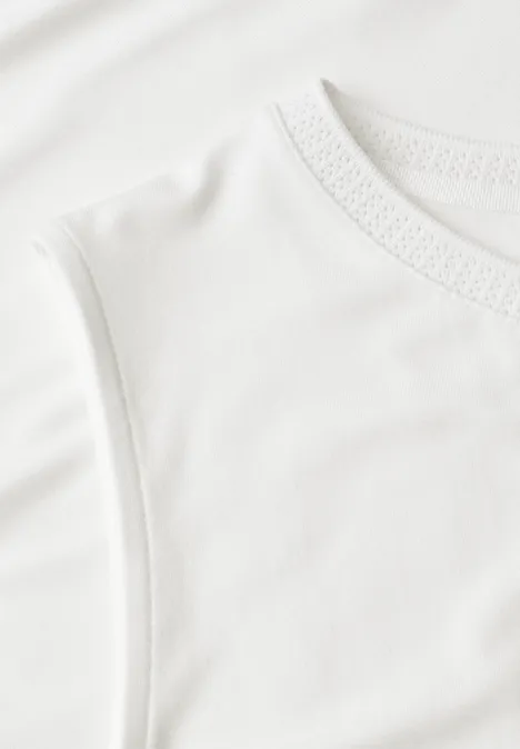 Nahaufnahme eines weißen, ärmellosen Baumwoll-T-Shirts mit feiner Struktur.