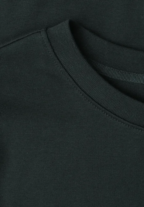 Close-up van de hals en het stiksel van een zwart T-shirt.
